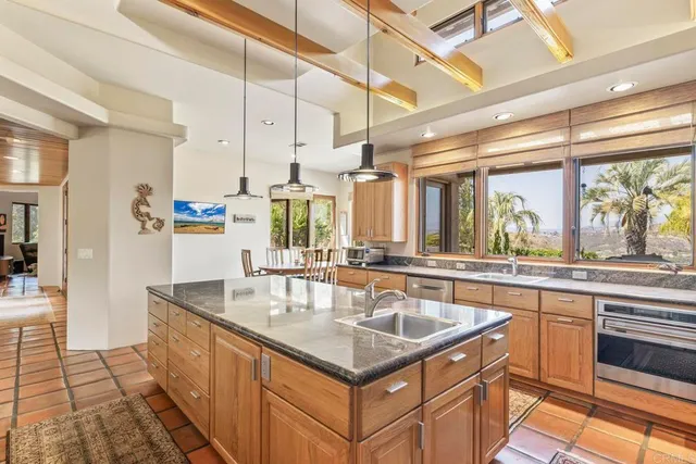 a kitchen with stainless steel appliances granite countertop a sink and wooden cabinets