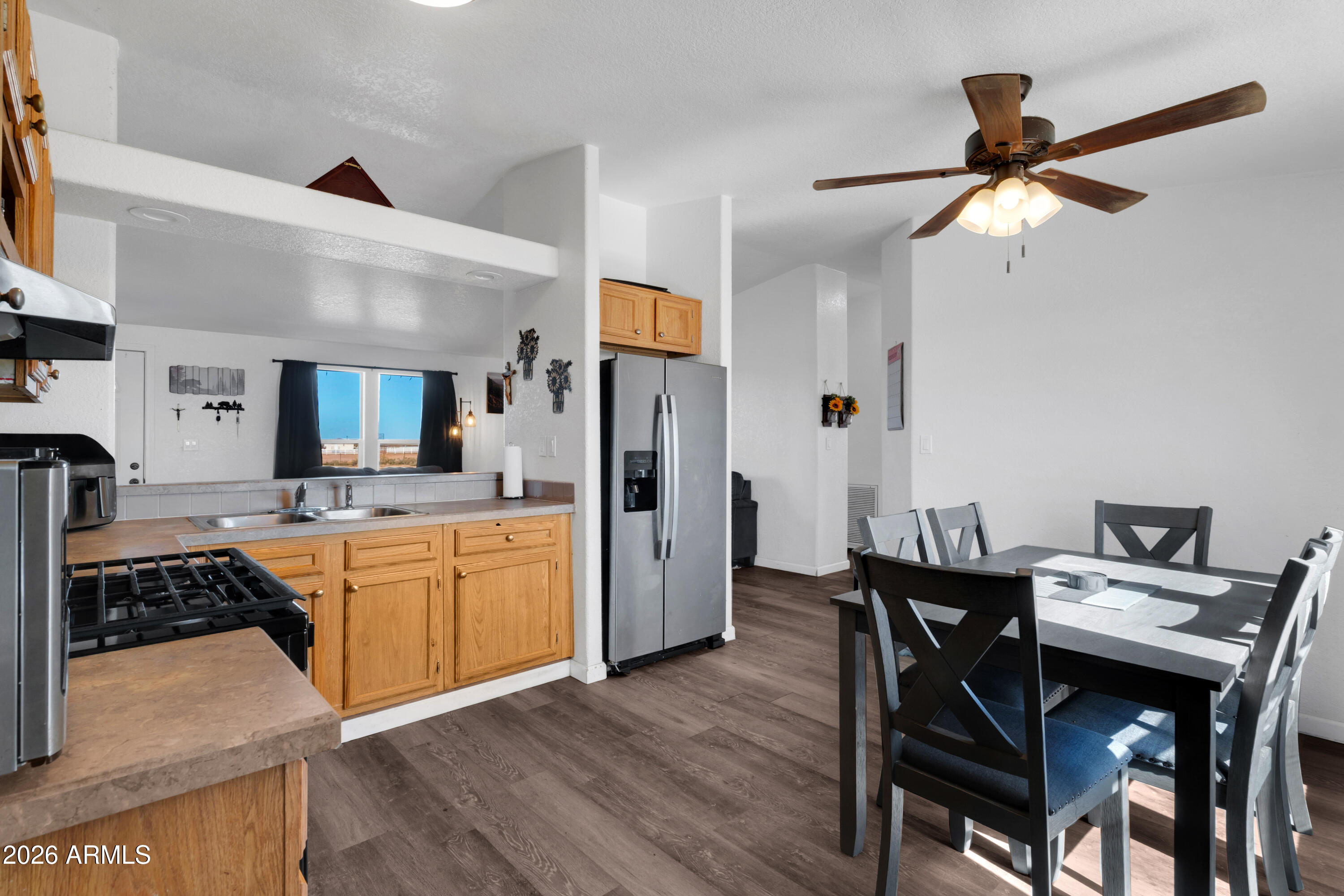 8902 Ghost Ranch Road Marana, AZ 85653 - Photo 6 of 28 a kitchen with a table chairs refrigerator and cabinets