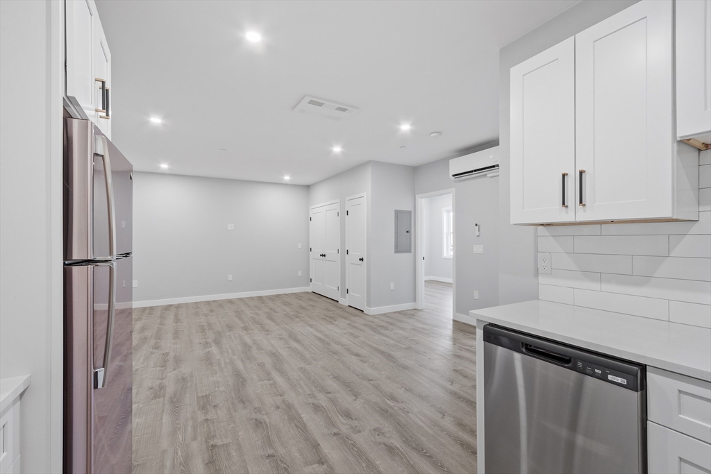 631 Franklin Street, Unit 106 Worcester, MA 01604 - Photo 11 of 36 a view of an empty room with wooden floor and staircase
