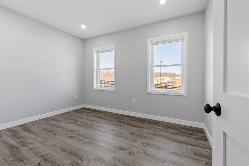 631 Franklin Street, Unit 106 Worcester, MA 01604 - Photo 15 of 36 a view of an empty room with wooden floor and a window