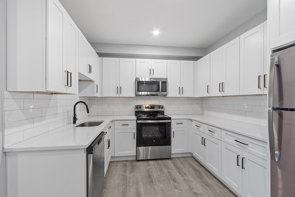 631 Franklin Street, Unit 106 Worcester, MA 01604 - Photo 8 of 36 a kitchen with stainless steel appliances granite countertop a sink stove and refrigerator