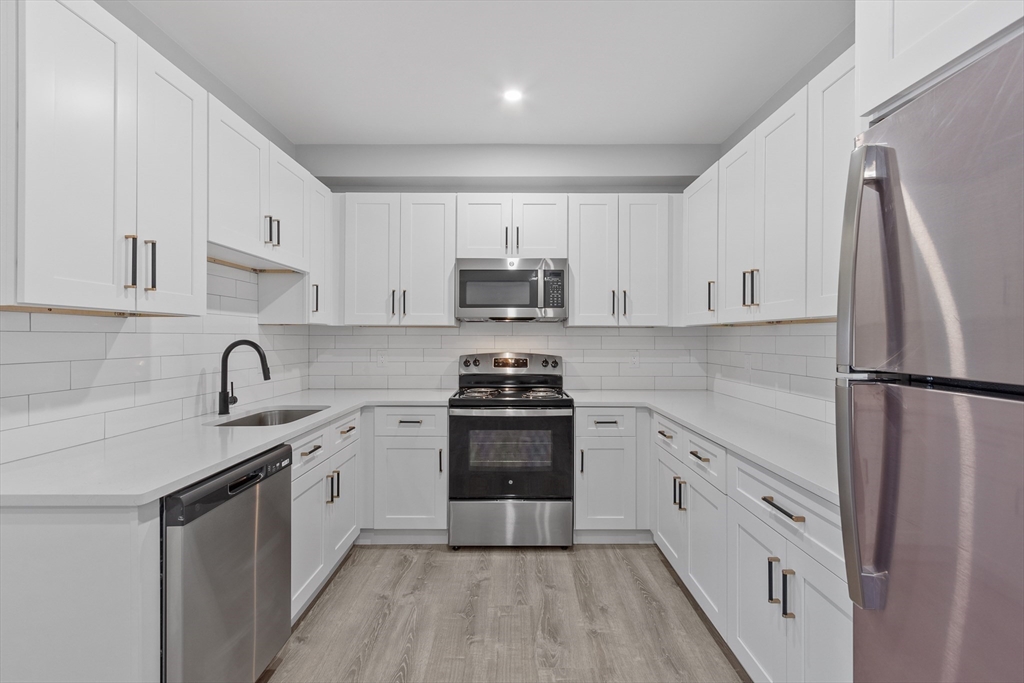 631 Franklin Street, Unit 106 Worcester, MA 01604 - Photo 9 of 36 a kitchen with white cabinets and stainless steel appliances