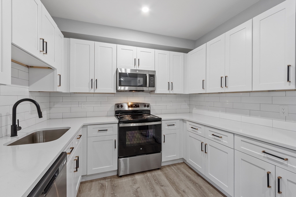 631 Franklin Street, Unit 106 Worcester, MA 01604 - Photo 10 of 36 a kitchen with white cabinets white stainless steel appliances and sink