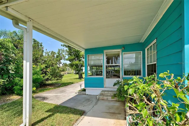 a view of a house with a yard and potted plants