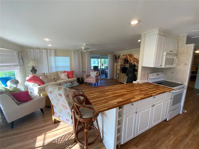 a bedroom with a bed a large window and wooden floor