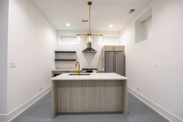 a kitchen with kitchen island a stove a sink and a refrigerator