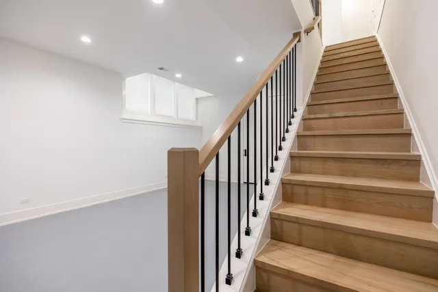 a view of staircase with wooden floor and white walls