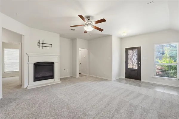 a view of an empty room with window and fireplace