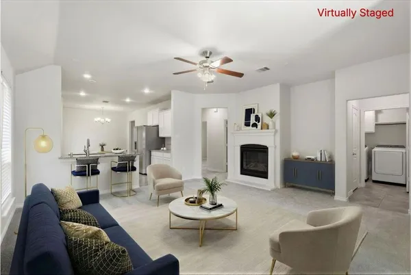 a living room with furniture a fireplace and a chandelier