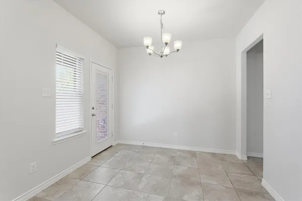 a kitchen with kitchen island a dining table chairs stainless steel appliances and cabinets