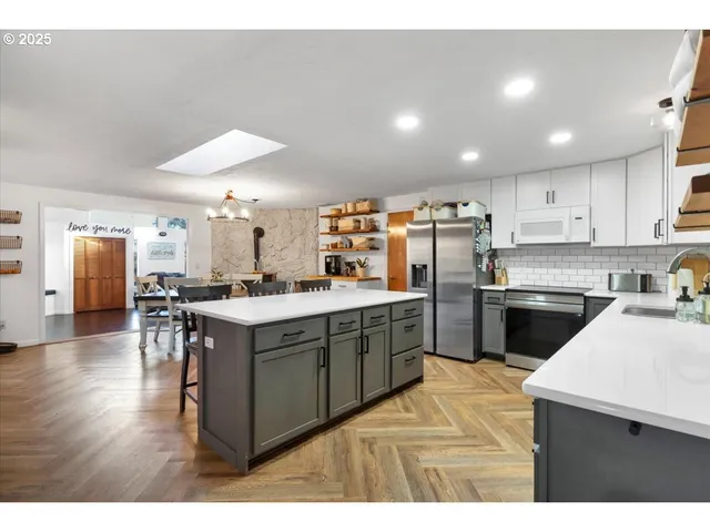 a kitchen with a sink a counter top space stainless steel appliances and cabinets