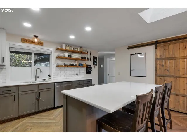 a kitchen with stainless steel appliances granite countertop a kitchen island a stove a table and chairs