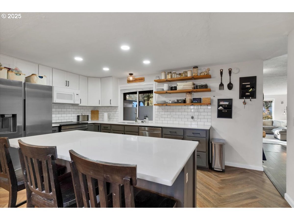 1855 Pilgrim Street Southeast Salem, OR 97302 - Photo 15 of 48 a kitchen with stainless steel appliances granite countertop a table chairs refrigerator and sink