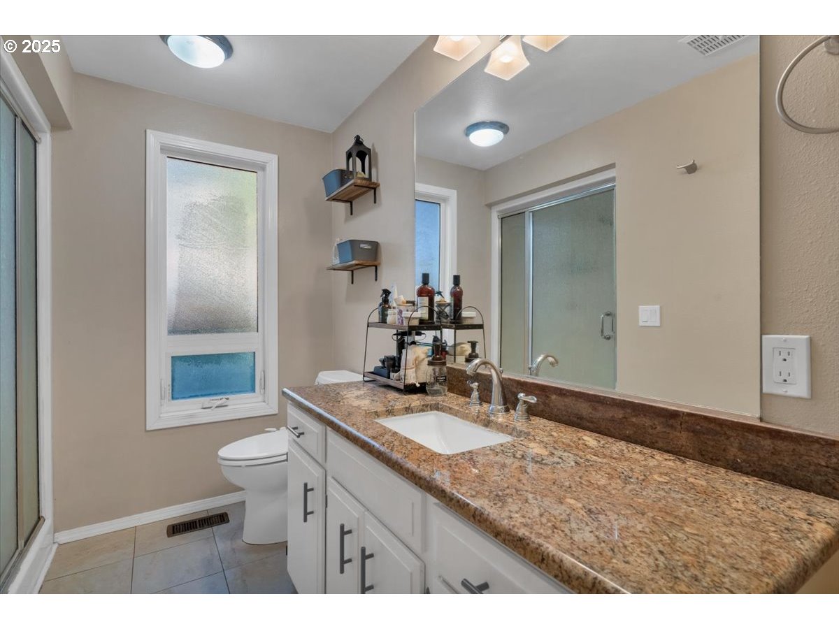 1855 Pilgrim Street Southeast Salem, OR 97302 - Photo 33 of 48 a bathroom with a granite countertop sink a mirror and a toilet