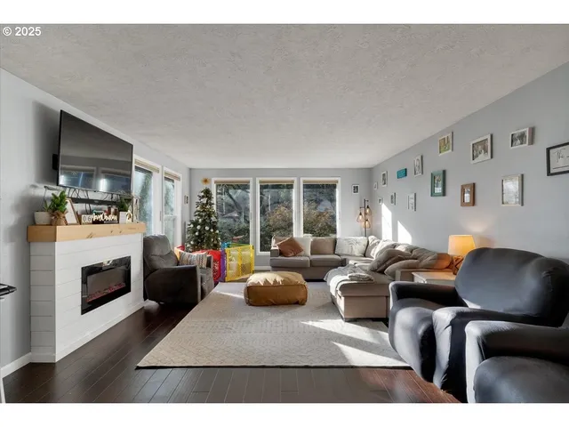 a living room with furniture a fireplace and a flat screen tv