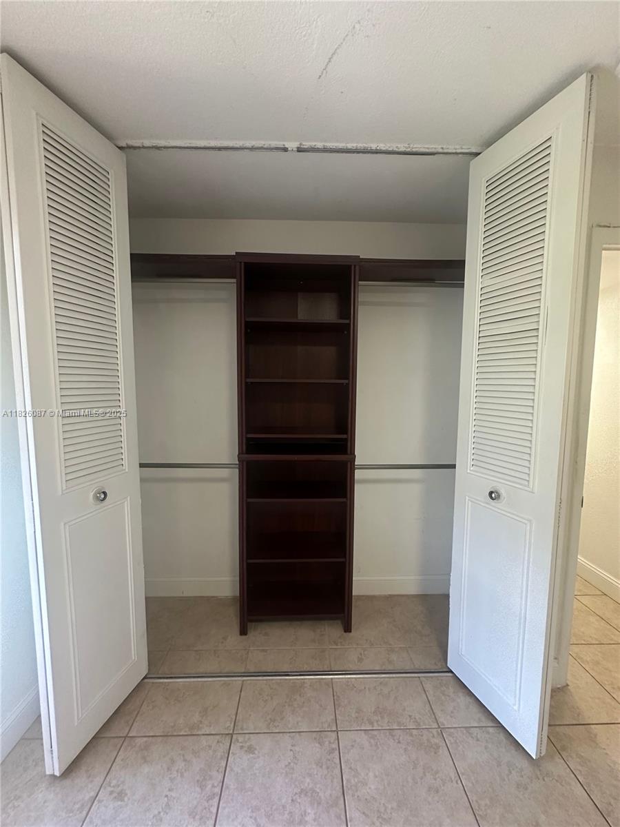 9487 Southwest 76th Street, Unit M8 Miami, FL 33173 - Photo 11 of 16 a view of walk in closet with empty racks