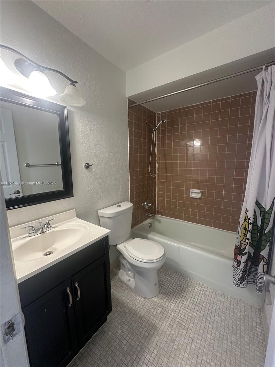 9487 Southwest 76th Street, Unit M8 Miami, FL 33173 - Photo 12 of 16 a bathroom with a sink a toilet and shower