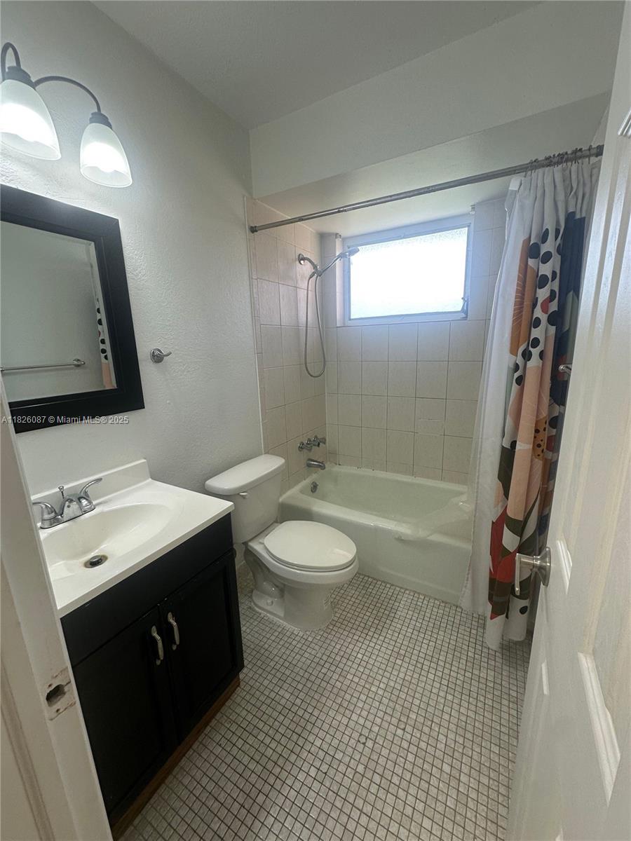 9487 Southwest 76th Street, Unit M8 Miami, FL 33173 - Photo 14 of 16 a bathroom with a sink a toilet a mirror and shower