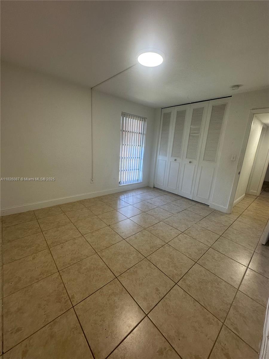 9487 Southwest 76th Street, Unit M8 Miami, FL 33173 - Photo 10 of 16 a view of an empty room and window