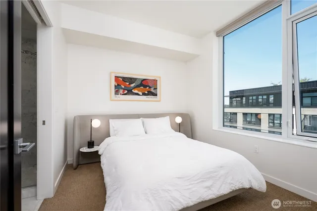 a bedroom with a bed and a painting on the wall