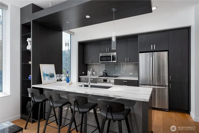 a kitchen with kitchen island a appliances dining table and chairs
