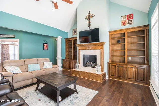 a living room with furniture and a wooden floor