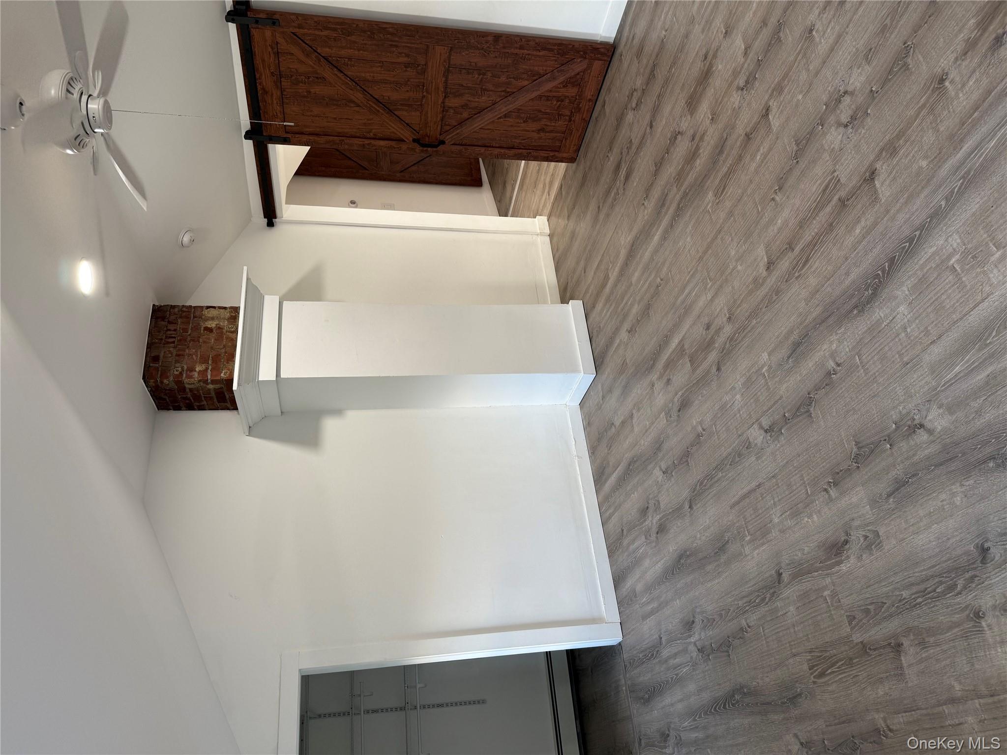 619 Salt Point Turnpike Poughkeepsie, NY 12601 - Photo 7 of 14 an empty room with wooden floor and a ceiling fan