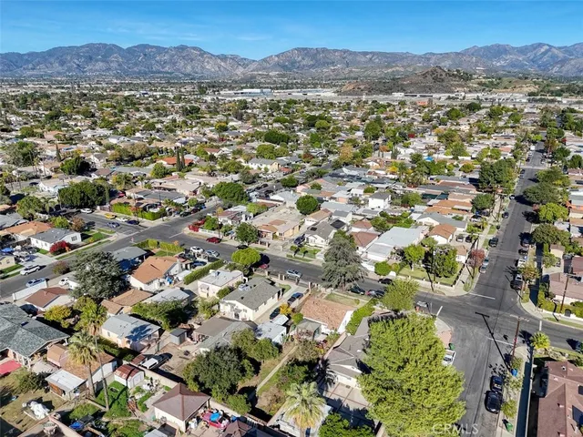an aerial view of a city with lots of residential buildings and mountain view in back