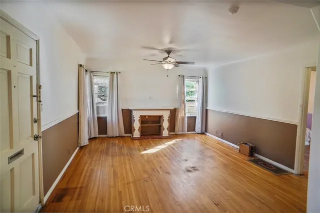 a view of a livingroom with wooden floor and a fireplace