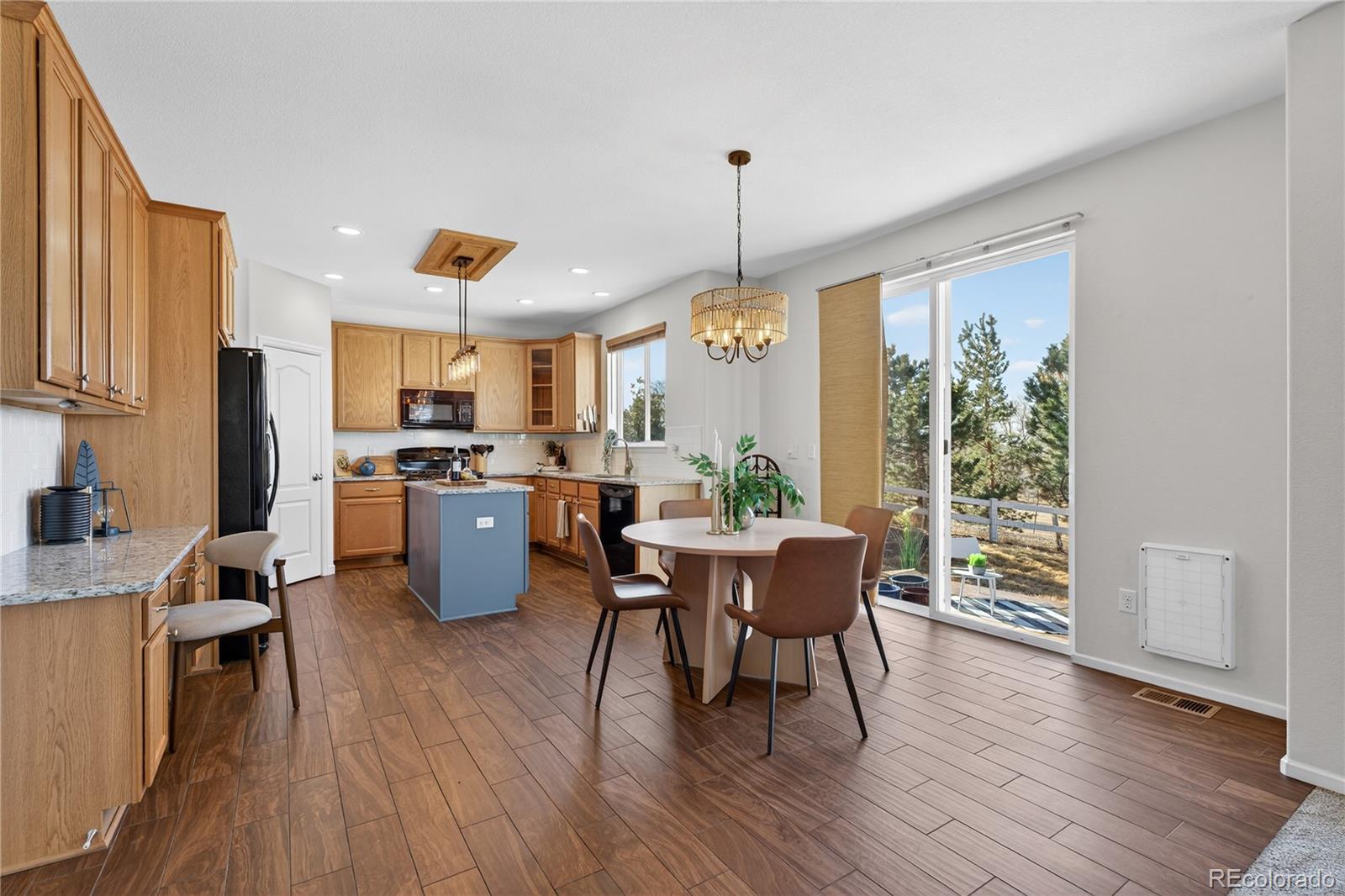 10180 Audrey Street Firestone, CO 80504 - Photo 13 of 46 a kitchen with stainless steel appliances a dining table chairs stove refrigerator and cabinets