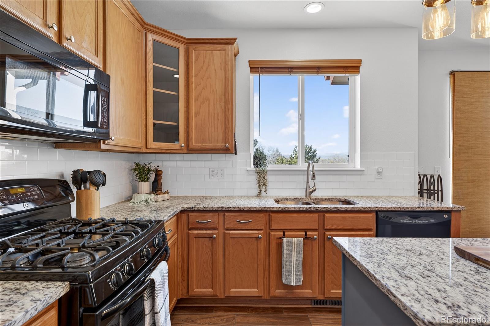 10180 Audrey Street Firestone, CO 80504 - Photo 15 of 46 a kitchen with granite countertop a stove sink and cabinets