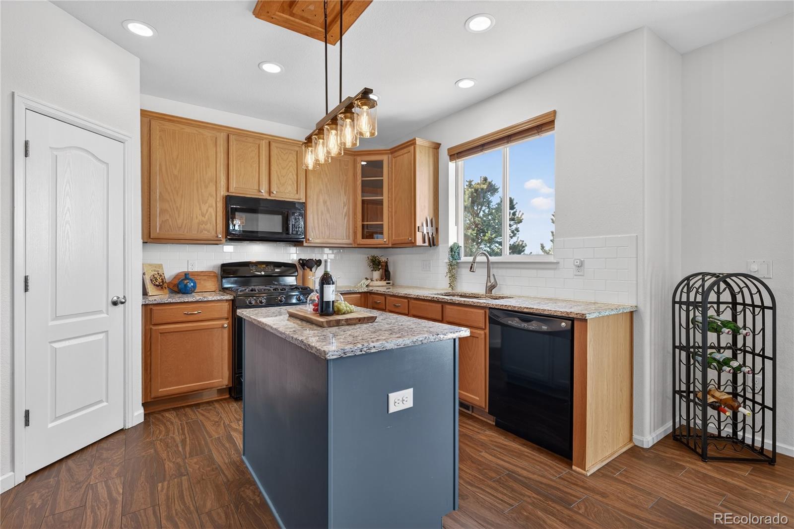 10180 Audrey Street Firestone, CO 80504 - Photo 16 of 46 a kitchen with stainless steel appliances granite countertop a stove a sink a refrigerator and a microwave