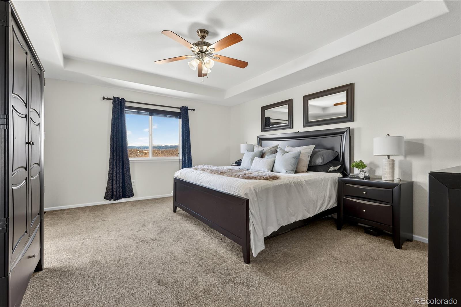 10180 Audrey Street Firestone, CO 80504 - Photo 22 of 46 a bedroom with a bed and a chandelier