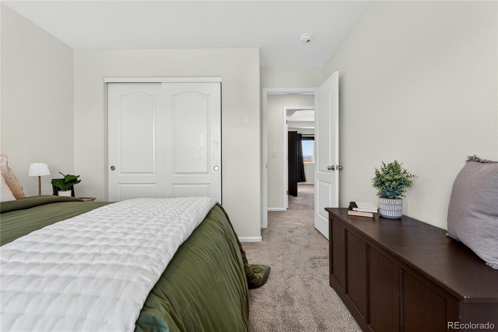 10180 Audrey Street Firestone, CO 80504 - Photo 28 of 46 a bedroom with a bed and a potted plant