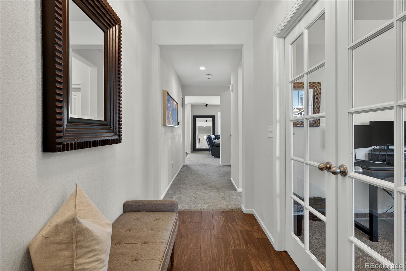 10180 Audrey Street Firestone, CO 80504 - Photo 7 of 46 a view of a hallway with wooden floor and staircase