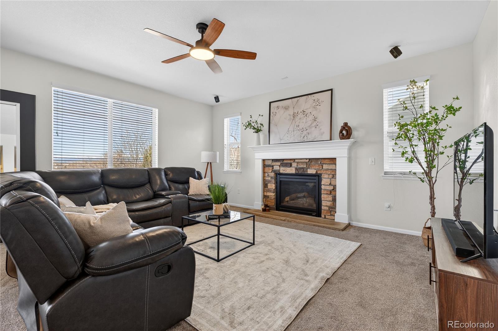 10180 Audrey Street Firestone, CO 80504 - Photo 10 of 46 a living room with furniture a window and a fireplace