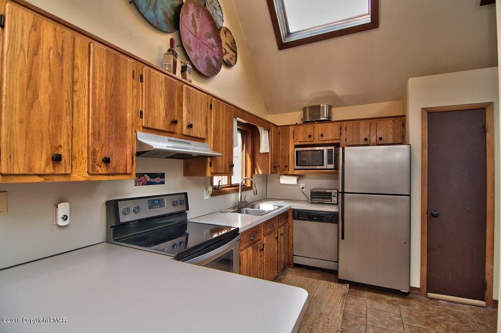 131 Powderhorn Road Long Pond, PA 18334 - Photo 18 of 54 a kitchen with stainless steel appliances a refrigerator a stove a sink and dishwasher with wooden cabinets