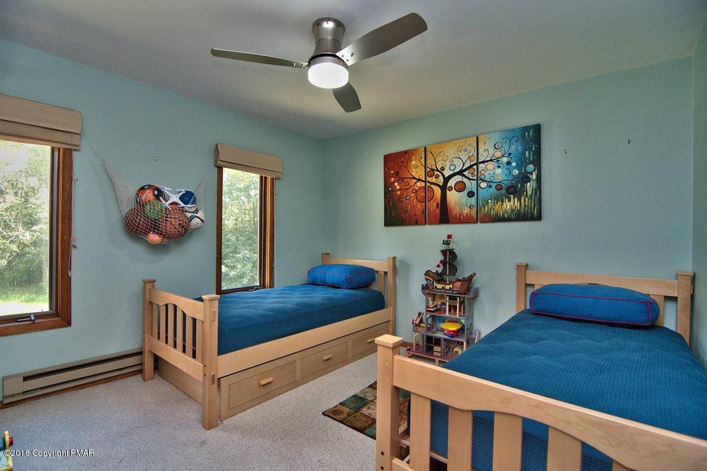 131 Powderhorn Road Long Pond, PA 18334 - Photo 29 of 54 a bedroom with furniture and a chandelier