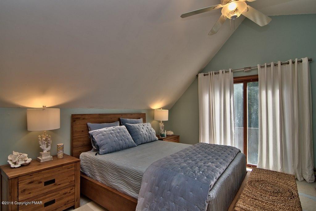 131 Powderhorn Road Long Pond, PA 18334 - Photo 42 of 54 a bedroom with a bed and a chandelier
