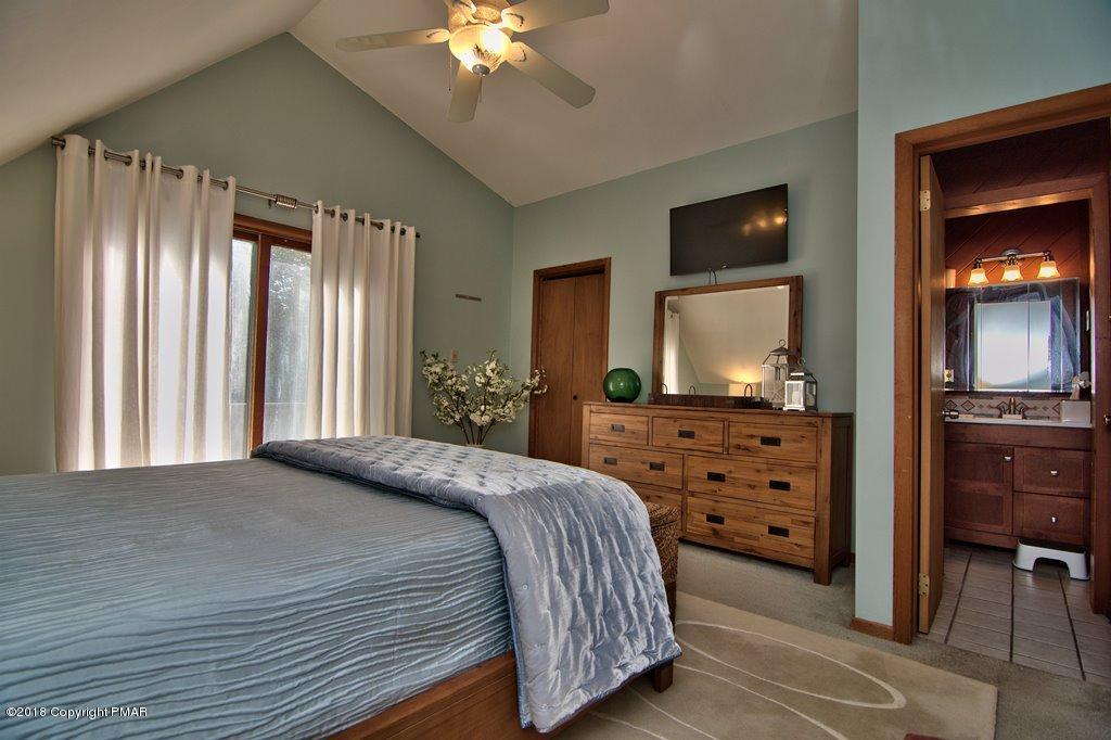131 Powderhorn Road Long Pond, PA 18334 - Photo 46 of 54 a bedroom with a large bed and a mirror on dresser