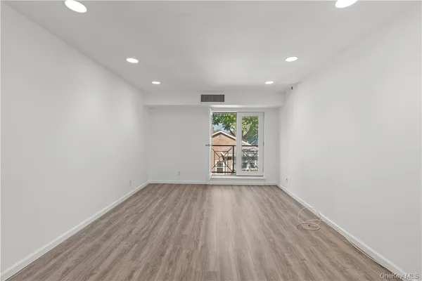 an empty room with wooden floor and a window