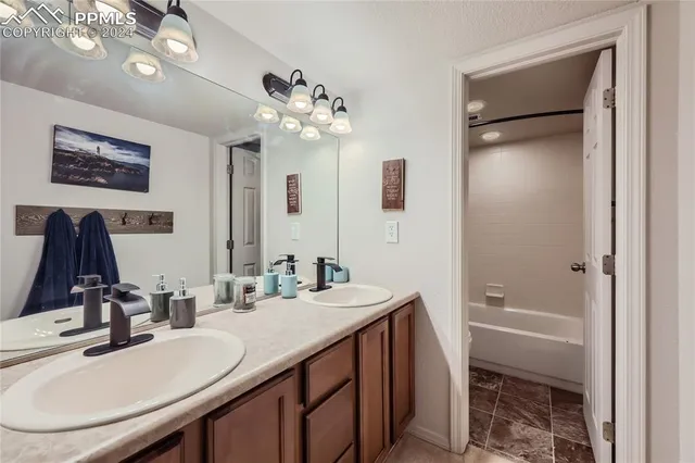 a bathroom with a tub a sink and mirror