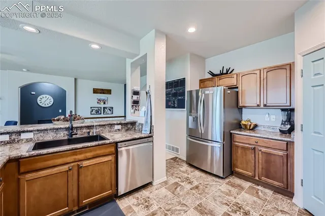 a kitchen with stainless steel appliances granite countertop a refrigerator and a sink