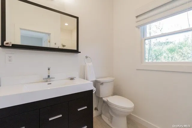 a bathroom with a toilet sink and mirror