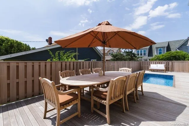 a patio with wooden floor a yard a table and chairs