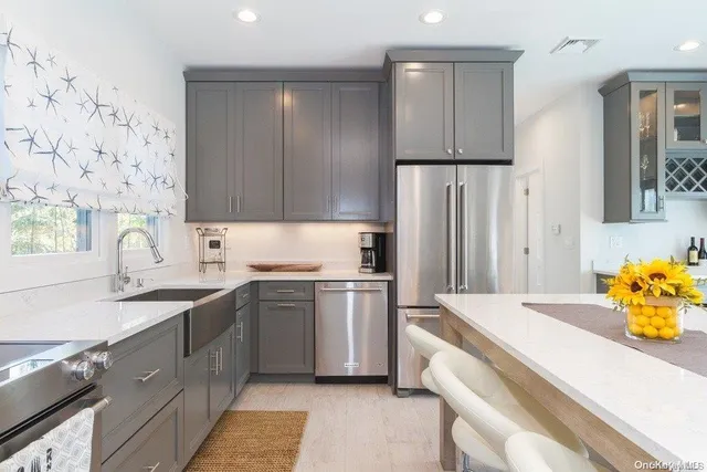 a kitchen with stainless steel appliances a sink a stove a refrigerator and cabinets