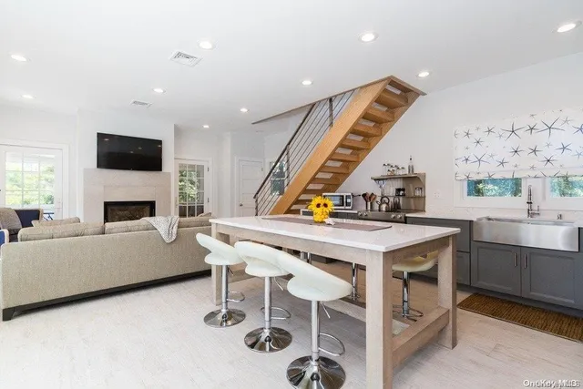 a kitchen with a table chairs a fireplace and a window