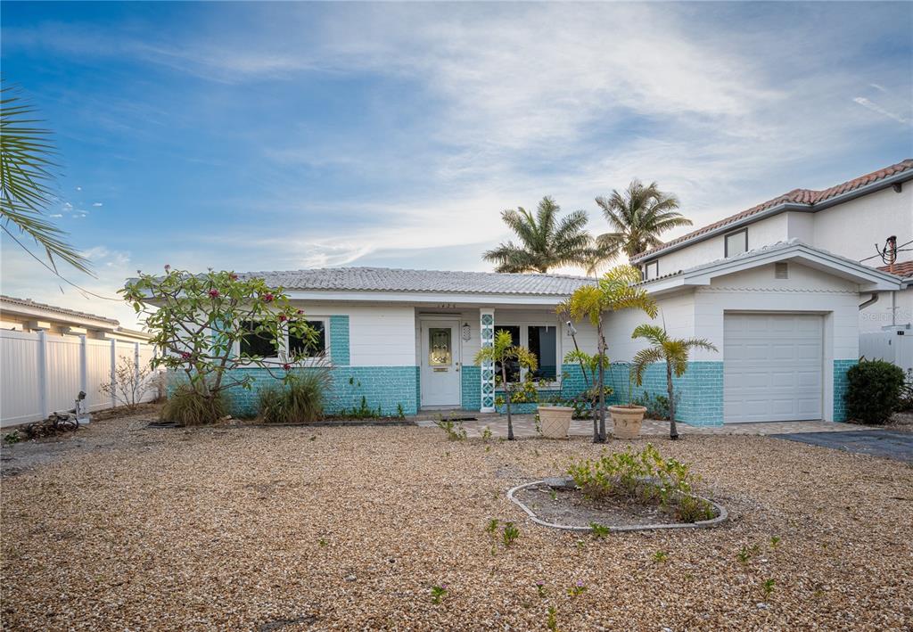 1425 Corey Way South South Pasadena, FL 33707 - Photo 30 of 34 a front view of a house with a yard and potted plants