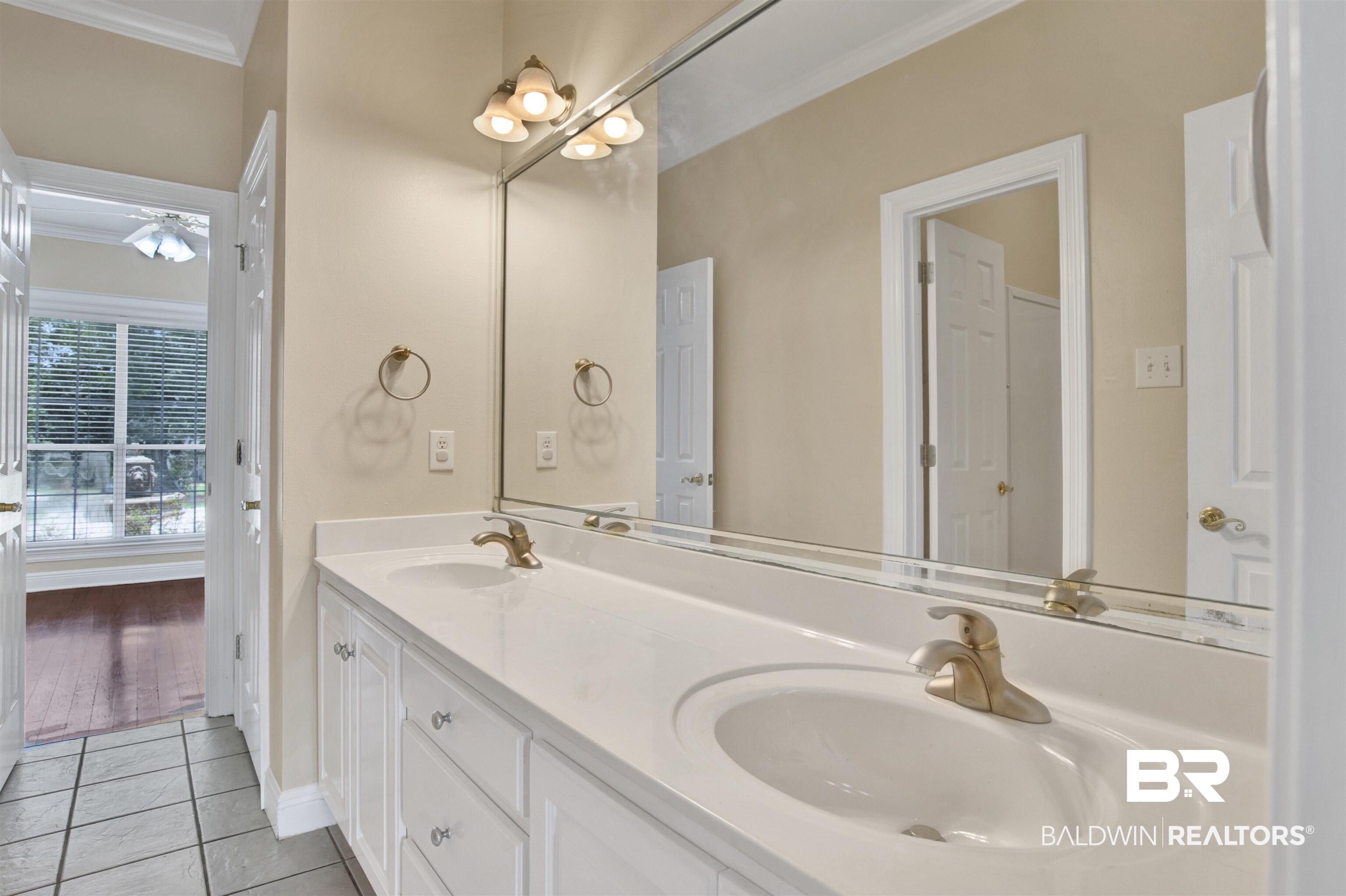 8847 Dawes Lake Road South Mobile, AL 36619 - Photo 17 of 47 Double vanity with white cabinetry, integrated sinks, and brushed gold fixtures