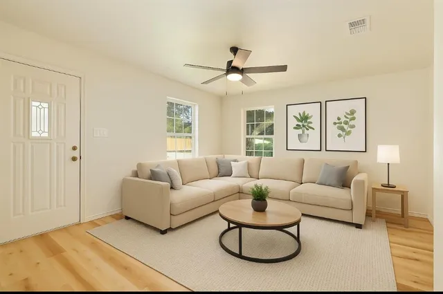 a living room with furniture a ceiling fan and a window